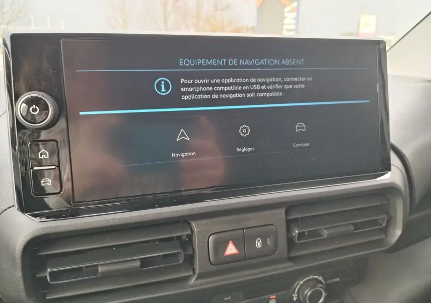 Écran central du tableau de bord du Peugeot Partner Fourgon blanc, affichant un message d'absence d'équipement de navigation.