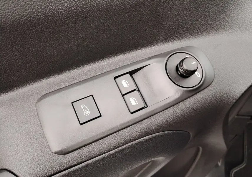 Gros plan sur les commandes de réglage des rétroviseurs et vitres côté conducteur du Peugeot Partner Fourgon blanc Icy 2025.