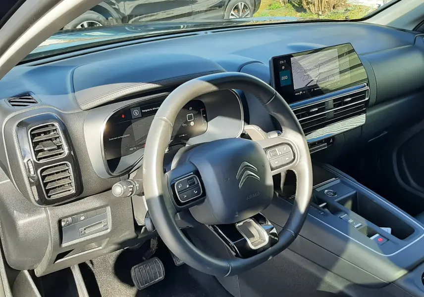 Intérieur de la Citroën C5 Aircross noir Perla Nera 2024, vue du poste de conduite avec tableau de bord numérique et écran central tactile.