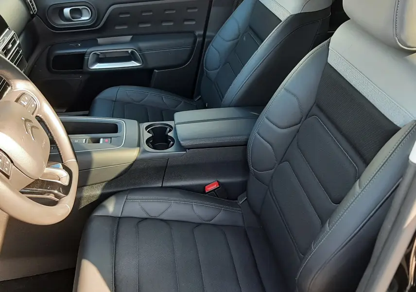 Vue intérieure côté avant droit du Citroën C5 Aircross 2024, sièges en cuir noir et gris avec console centrale.