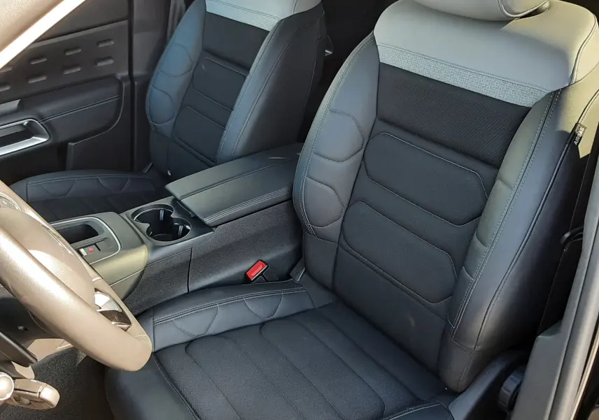 Vue intérieure côté conducteur du Citroën C5 Aircross 2024, sièges bi-matière gris clair et noir avec console centrale.