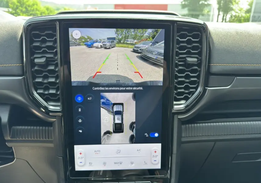 Vue intérieure centrée sur l'écran tactile du Ford Ranger Wildtrak 2025, affichant la caméra 360° et l'aide au stationnement.