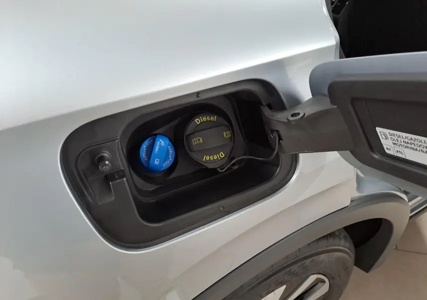 Gros plan sur la trappe à carburant côté gauche du Volkswagen Tiguan 2025 argent Dolomite avec bouchons Diesel et AdBlue visibles.