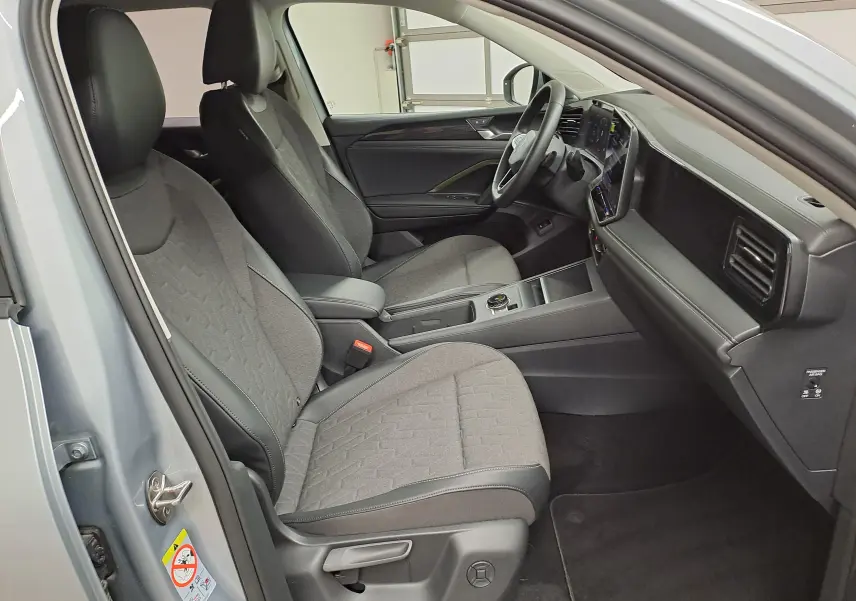 Vue intérieure côté conducteur du Volkswagen Tiguan 2025 argent Dolomite, avec sièges et volant chauffants visibles.