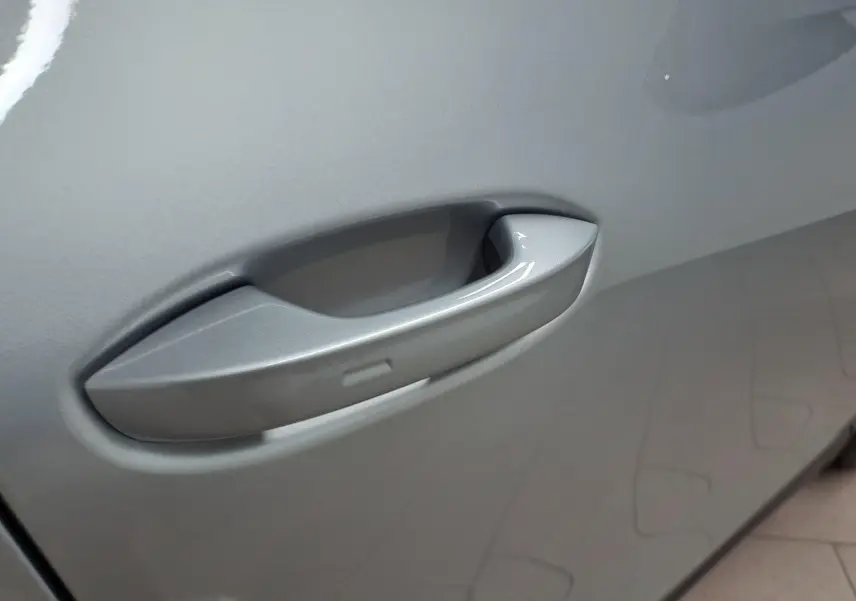 Gros plan sur la poignée de porte côté gauche du Volkswagen Tiguan 2025 en peinture métallisée Argent Dolomite.
