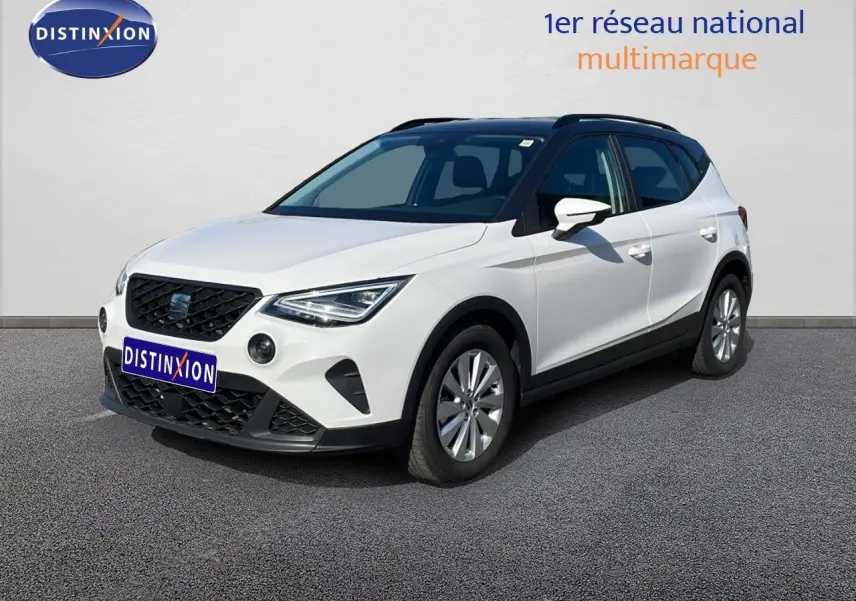SEAT Arona blanc avec toit gris en 3/4 avant droit, mettant en valeur ses optiques LED et sa calandre noire.