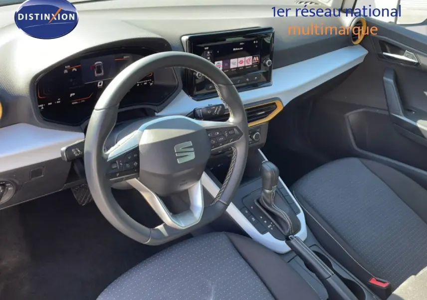Vue intérieure côté conducteur du SEAT Arona blanc toit gris 2025, avec tableau de bord digital et volant cuir multifonction.