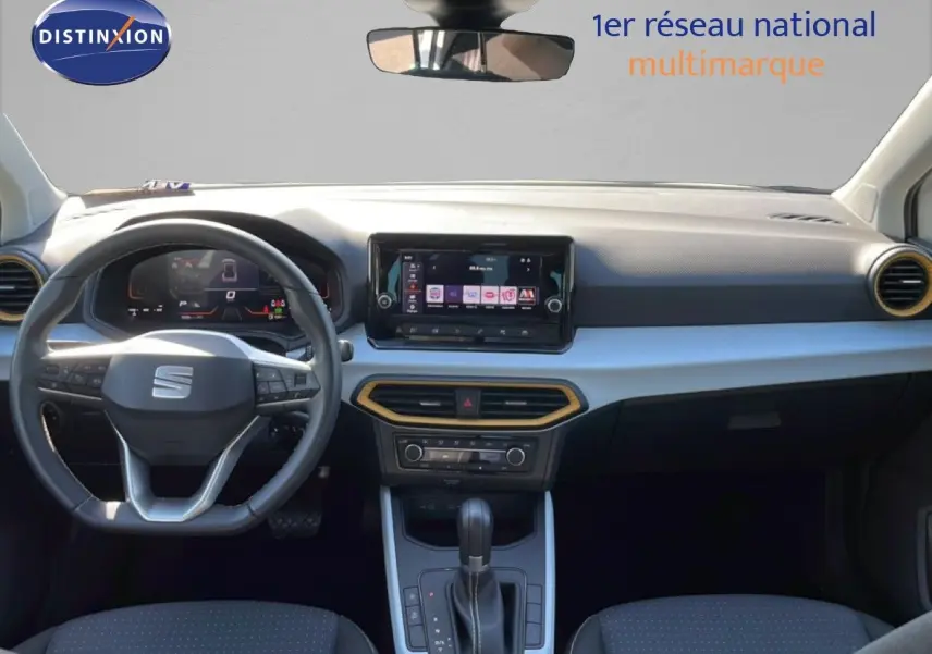 Vue intérieure avant du SEAT Arona 2025, tableau de bord noir avec écran tactile central et volant multifonction cuir.