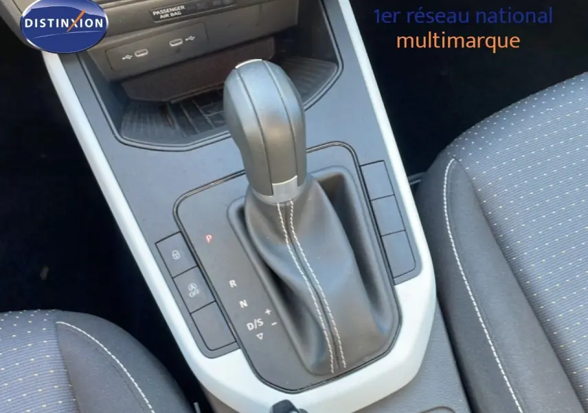 Gros plan sur la console centrale et le levier de vitesse automatique en cuir noir avec surpiqûres blanches du SEAT Arona 2025.