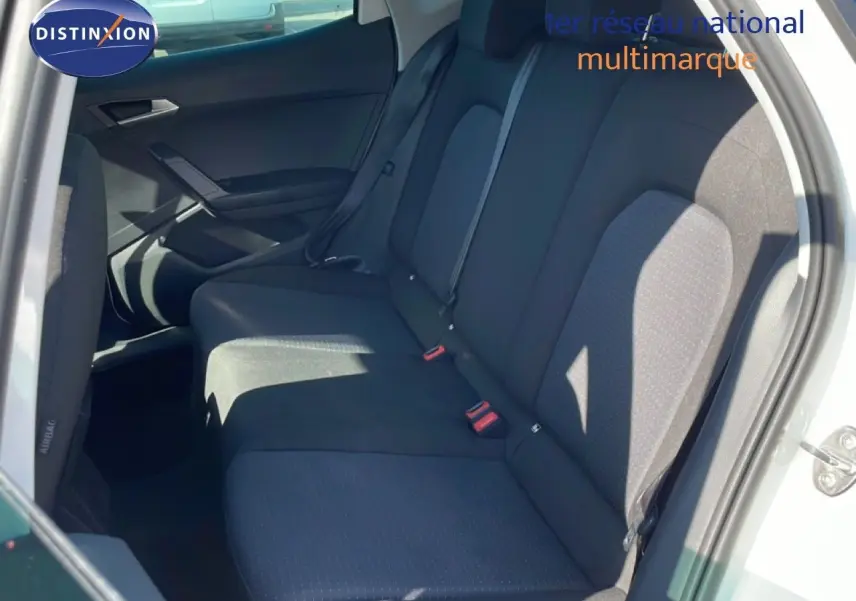 Vue intérieure côté droit montrant la banquette arrière noire du SEAT Arona blanc avec toit gris, porte ouverte.