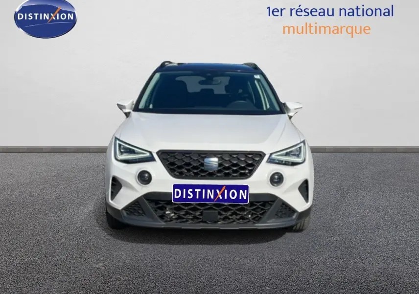 Vue avant d'un SEAT Arona blanc avec toit gris, calandre noire et feux LED distinctifs, sur fond neutre.