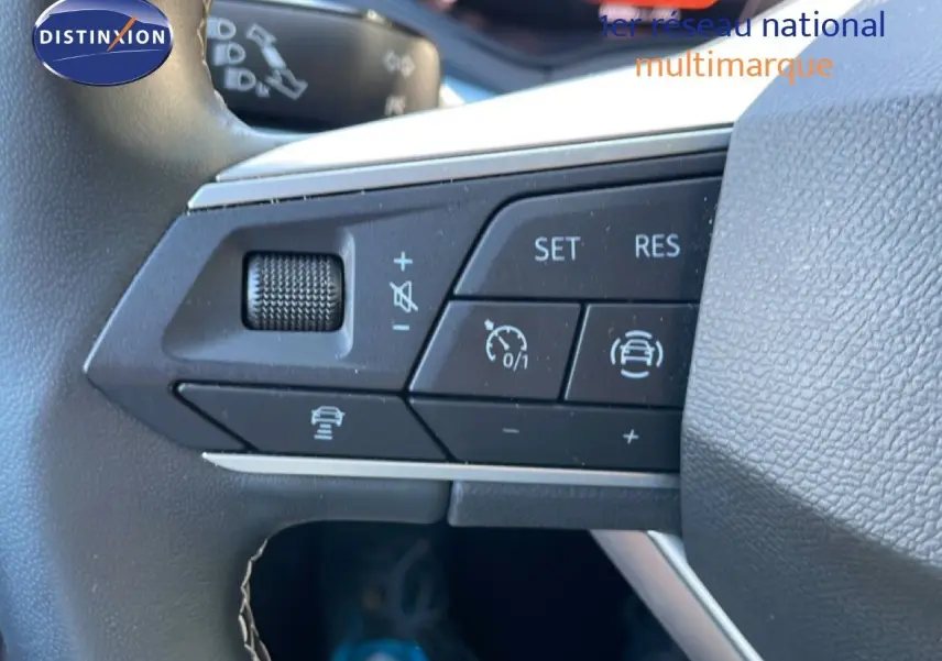 Gros plan sur les commandes au volant du SEAT Arona 2025, boutons de régulateur de vitesse et assistance à la conduite visibles.