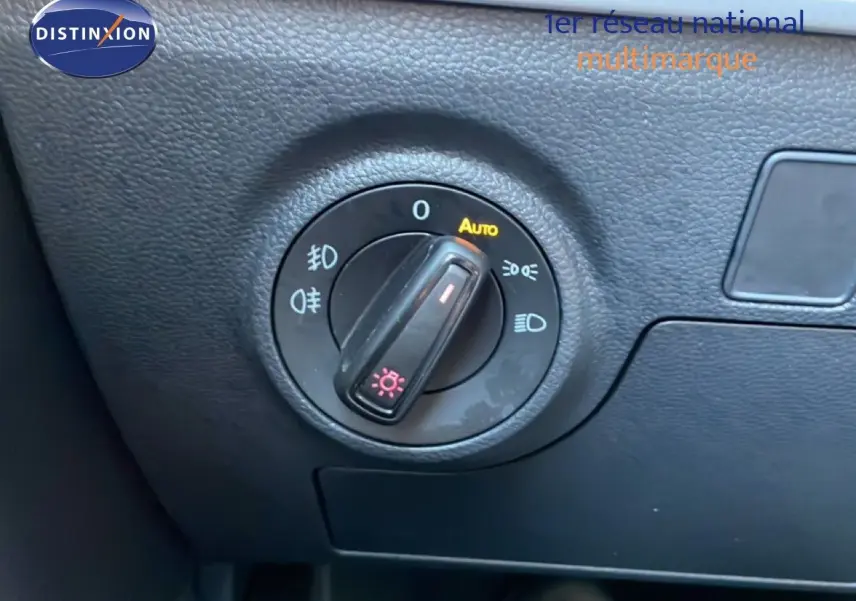 Gros plan sur le bouton de commande des phares dans l’habitacle noir du SEAT Arona blanc toit gris 2025.
