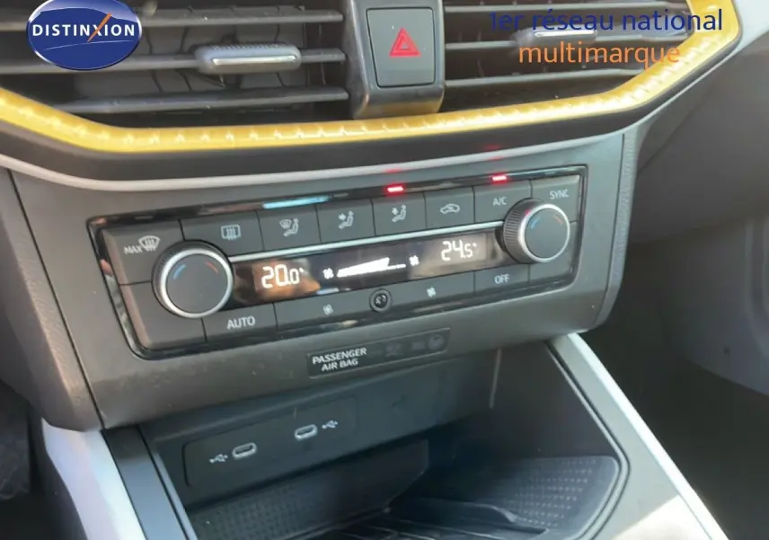 Détail de la console centrale du SEAT Arona 2025, montrant la climatisation automatique avec affichage digital et commandes rotatives.