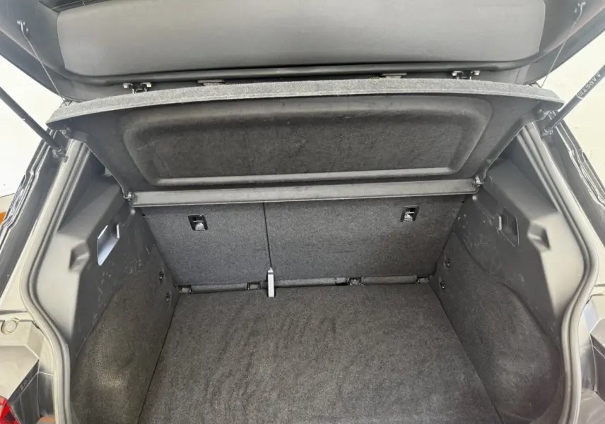Coffre ouvert vu de l'arrière d'une CUPRA Born gris foncé, montrant l'espace de chargement et la tablette cache-bagages.