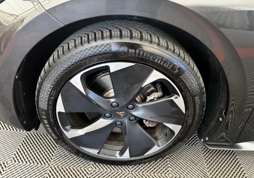 Gros plan sur la roue avant droite d'une CUPRA BORN gris foncé avec jante noire et argentée au design moderne.