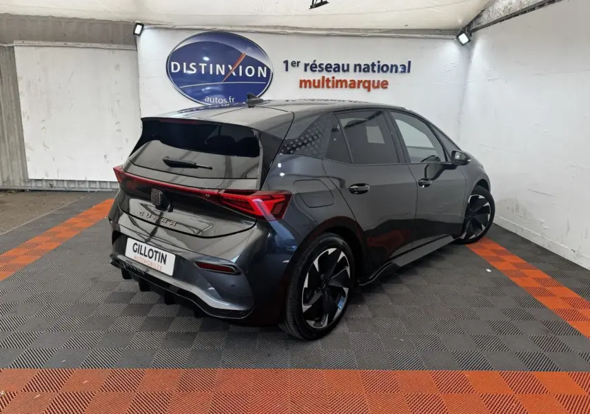 Vue 3/4 arrière droite d'une CUPRA BORN gris foncé avec jantes noires et feux arrière LED distinctifs.