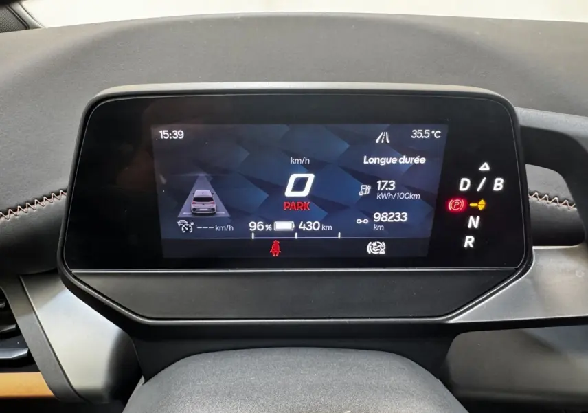 Gros plan sur le combiné d'instruments numérique du tableau de bord du CUPRA BORN gris foncé, affichage digital en marche.