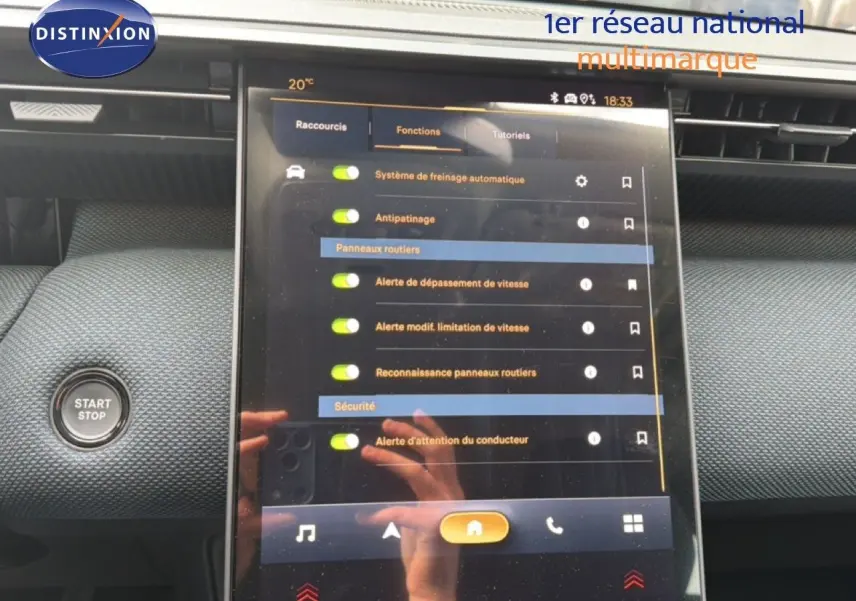 Vue rapprochée de l’écran tactile central du Citroën C5 Aircross Hybrid 2026 avec interface de réglages de sécurité et bouton Start/Stop.