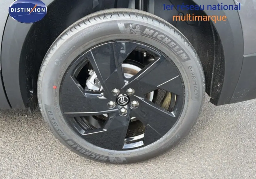 Gros plan sur la roue avant gauche du Citroën C5 Aircross gris platinium avec jante noire au design moderne.