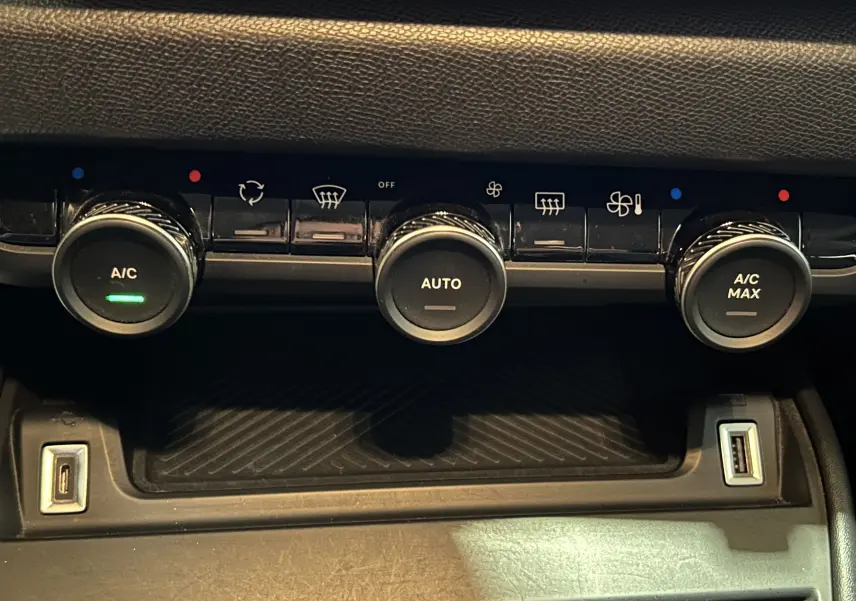 Gros plan sur la console centrale de la Citroën C4 PureTech 100 Feel 2021, avec commandes de climatisation et ports USB visibles.