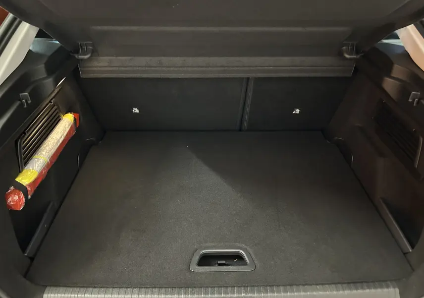 Coffre ouvert d'une Citroën C4 PureTech 100 Feel 2021, vue intérieure sur le plancher et les côtés noirs du coffre.