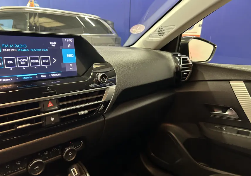 Vue intérieure côté passager du tableau de bord noir et de la portière d'une Citroën C4 PureTech 100 Feel 2021.