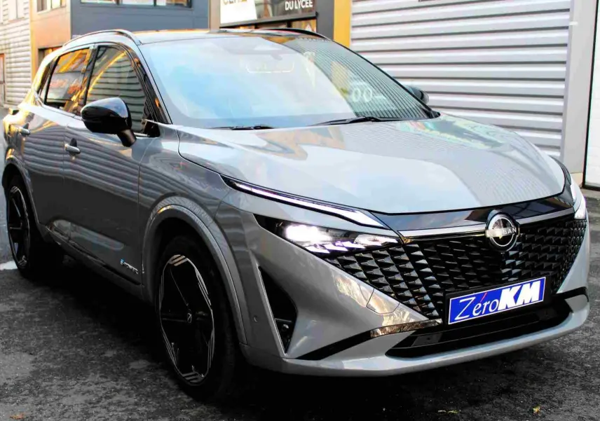 Gros plan sur les commandes au volant du Nissan Qashqai 2025, finition N-Design, avec tableau de bord numérique en arrière-plan.