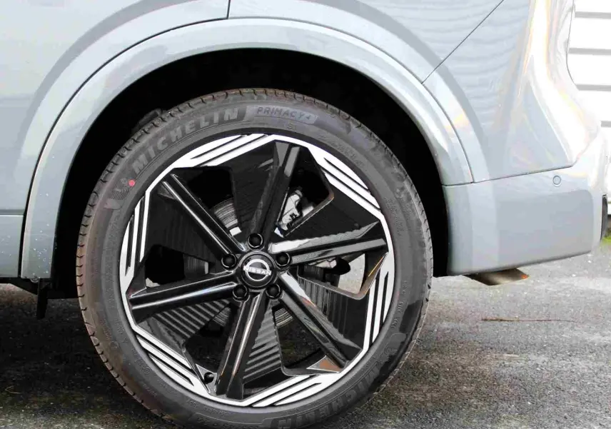 Gros plan sur les commandes de régulateur de vitesse au volant cuir noir du Nissan Qashqai gris céramique 2025.