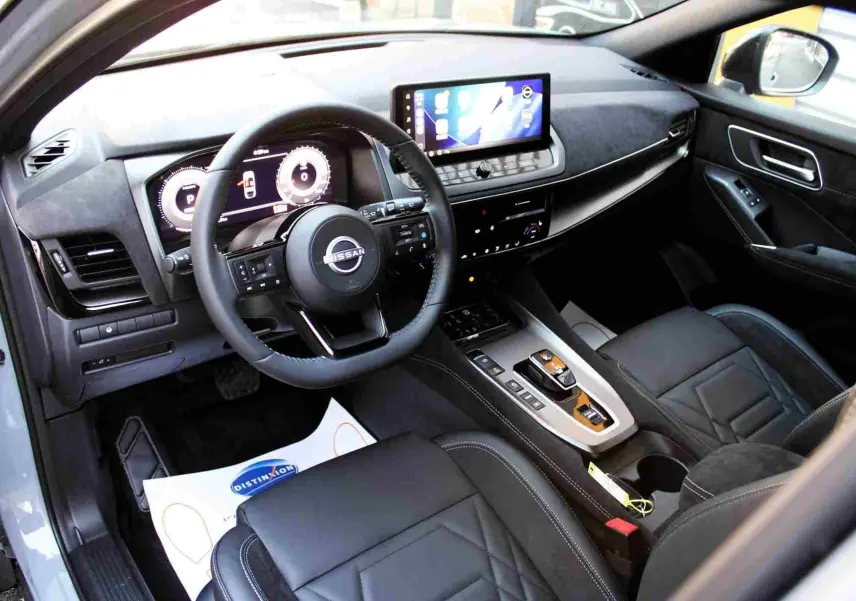 Gros plan sur la console centrale du Nissan Qashqai 2025 gris céramique, montrant les commandes de boîte auto et fonctions hybrides.