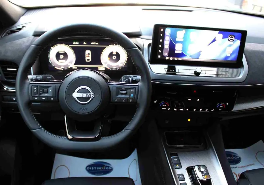 Détail du chargeur sans fil et bouton start/stop dans l'habitacle du Nissan Qashqai 2025 gris céramique.