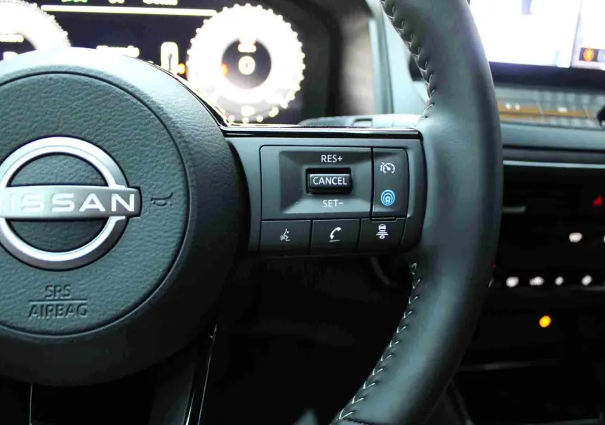 Vue intérieure du tableau de bord du Nissan Qashqai 2025 avec écran tactile affichant une carte et options Bluetooth.