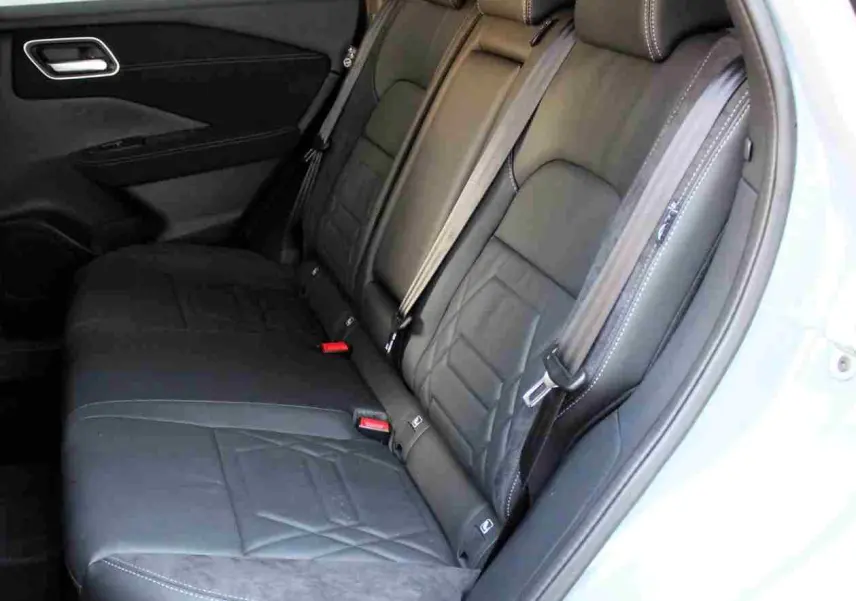 Nissan Qashqai 2025 gris céramique avec toit noir, vue 3/4 arrière côté gauche, roues noires distinctives.