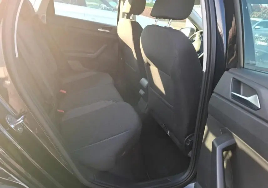 Vue intérieure côté gauche sur la banquette arrière noire d'une Volkswagen Polo 1.0 TSI 95 DSG7 Life 2022 avec porte ouverte.