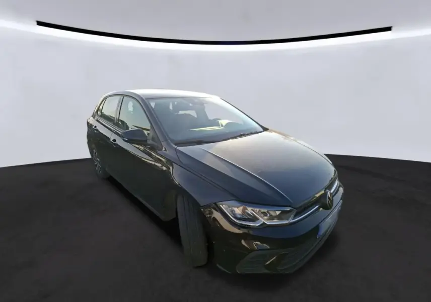 Volkswagen Polo 1.0 TSI noire vue 3/4 avant droit, avec calandre chromée et feux LED distinctifs.