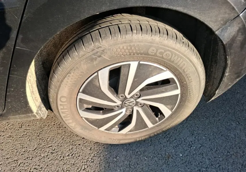 Gros plan sur la roue avant gauche noire d’une Volkswagen Polo 1.0 TSI 95 DSG7 Life avec jante alliage au design moderne.