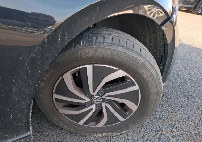 Gros plan sur la roue avant droite noire d'une Volkswagen Polo 1.0 TSI 95 DSG7 Life avec jante alliage bicolore.