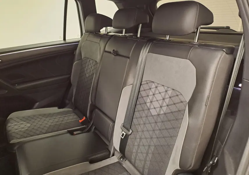 Vue intérieure côté droit des sièges arrière en cuir noir et tissu gris à motifs du Volkswagen Tiguan Allspace 2023 R-Line.