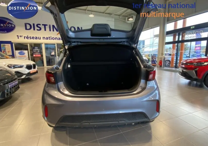 Vue arrière d'une MG3 1.5 Hybrid 2024 gris Hampstead avec coffre ouvert dans un showroom lumineux.
