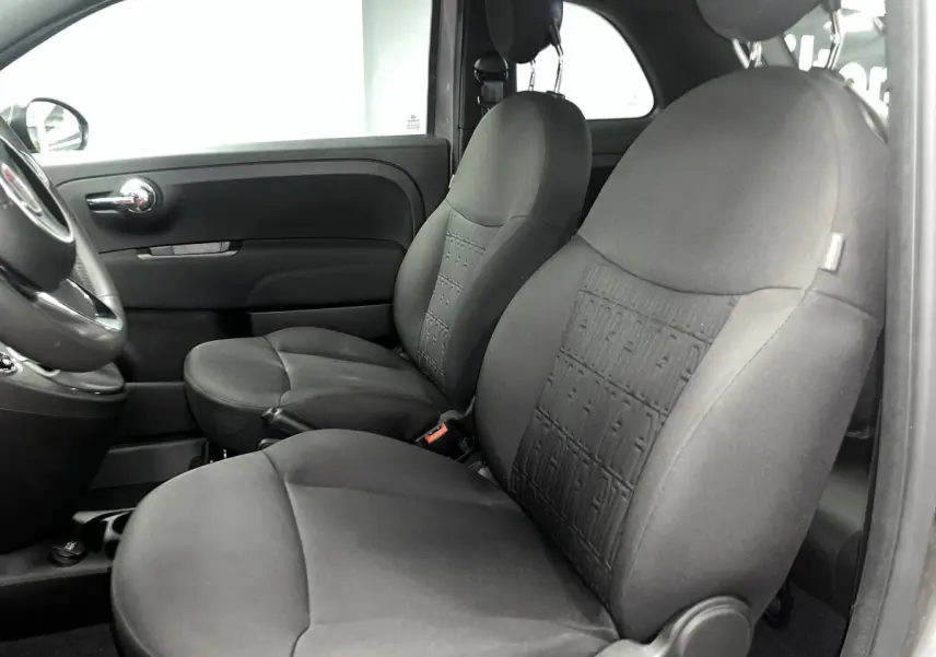 Vue intérieure côté gauche montrant les sièges avant en tissu noir avec monogramme FIAT sur la Fiat 500 gris 2023.