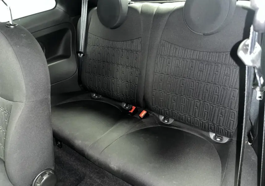 Vue rapprochée de la banquette arrière noire avec monogramme FIAT en tissu dans une Fiat 500 gris 2023.