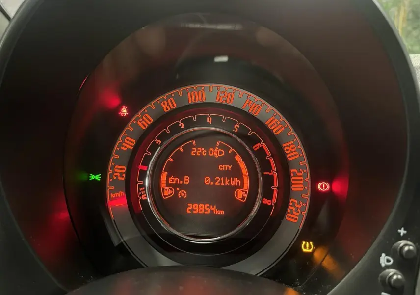 Gros plan sur le combiné d'instrumentation orange de la Fiat 500 gris, affichant 29854 km et mode City activé.