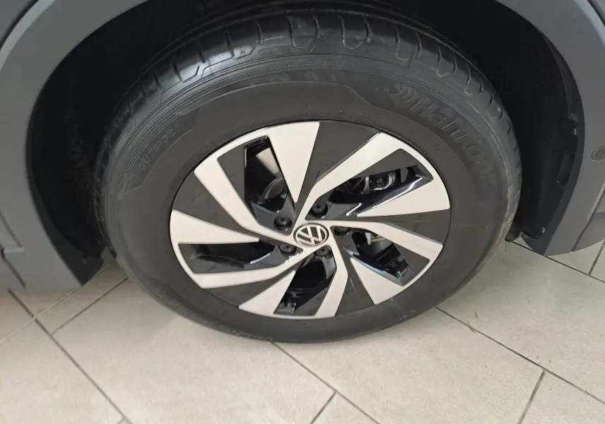 Gros plan sur la roue avant droite du Volkswagen Tiguan 2024 gris Urano avec jante alliage bicolore et pneu Hankook.