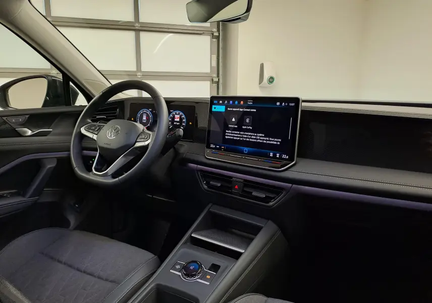 Vue intérieure côté conducteur du Volkswagen Tiguan 2024, tableau de bord moderne avec écran tactile et volant multifonction.