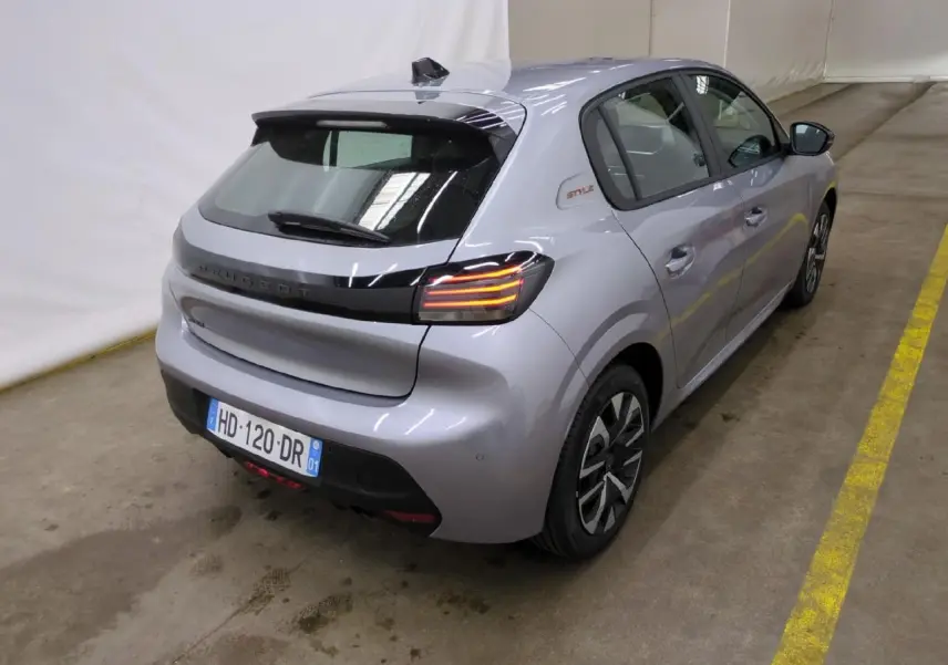 Vue 3/4 arrière droite d'une Peugeot 208 gris clair avec badge Style sur custode et feux arrière à LED 3 griffes.