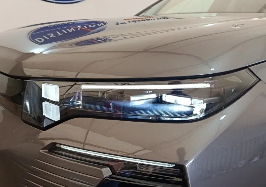 Gros plan sur le phare avant droit LED d'une Citroën C5 hybride gris foncé avec éclairage diurne fin et moderne.