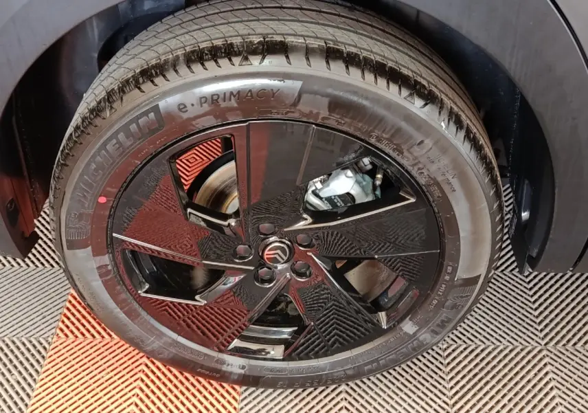 Gros plan sur la roue avant droite gris foncé d'une Citroën C5 Hybride avec jante noire au design géométrique.
