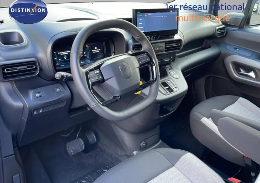 Vue intérieure côté conducteur du Citroën Berlingo blanc glacier 2025, volant multifonction et écran tactile central visibles.