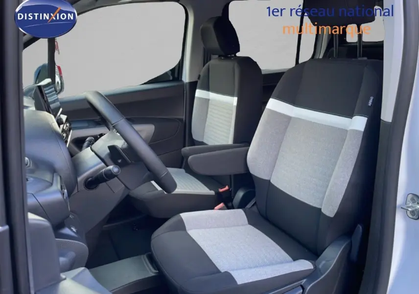 Vue intérieure côté conducteur du Citroën Berlingo Multispace 2025, sièges tissu bicolore gris et noir, volant multifonction.
