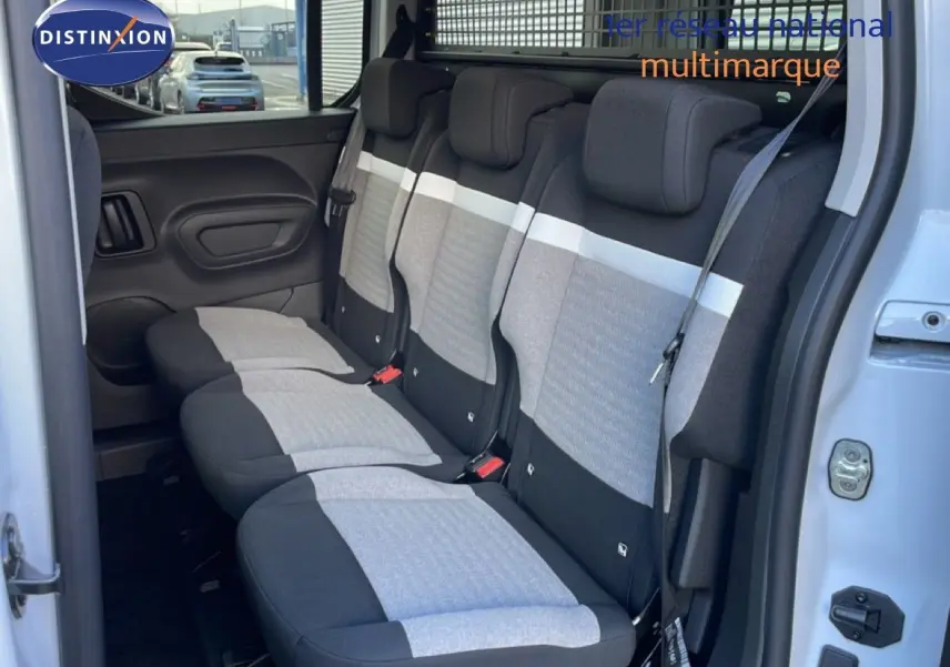 Vue intérieure montrant la banquette arrière en tissu gris et noir du Citroën Berlingo Multispace blanc glacier, porte ouverte côté droit.